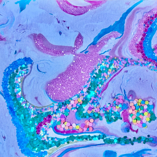 Colorful abstract art piece with glitter on a textured surface