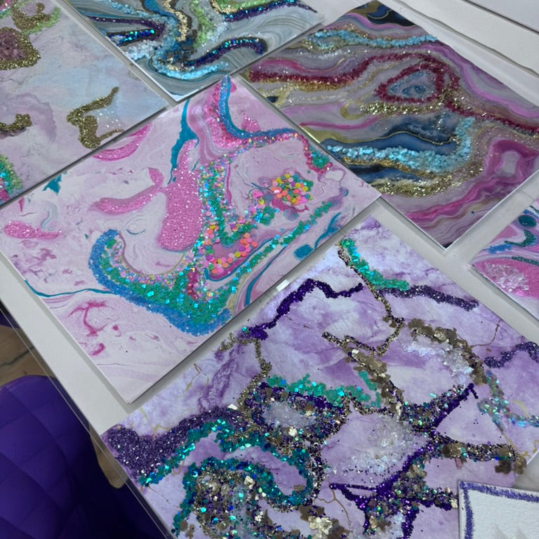 Colorful abstract designs on paper with glittery textures.